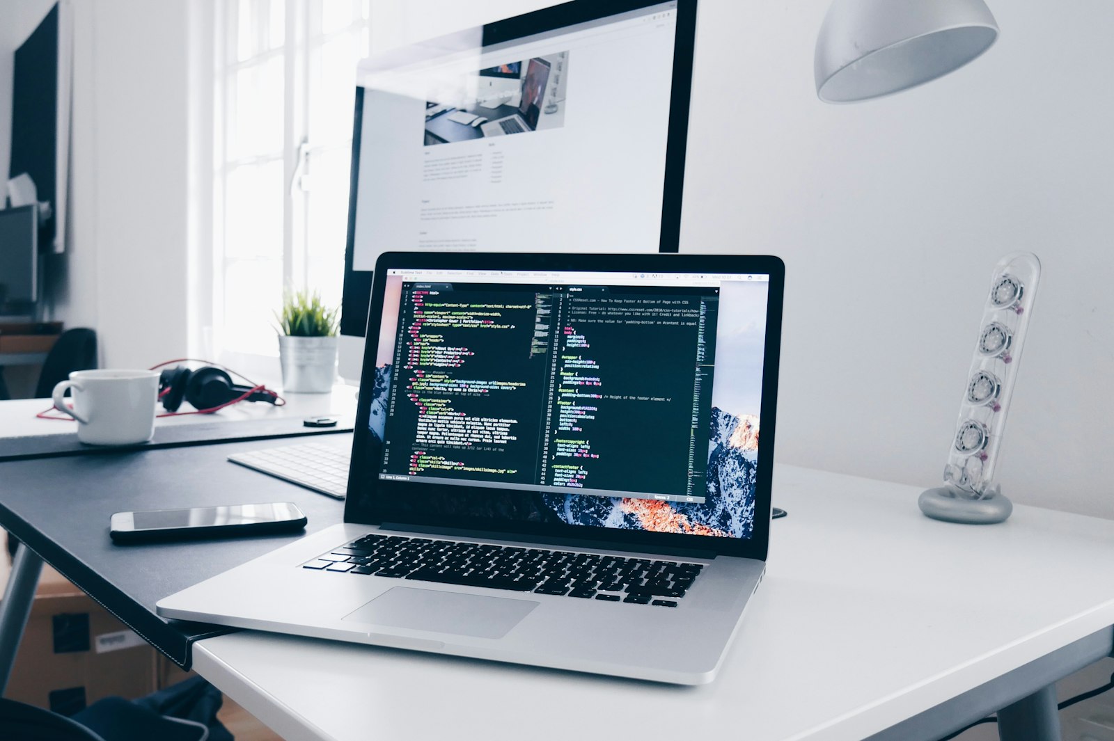 Escritorio de desarrollo de software con código en pantalla.